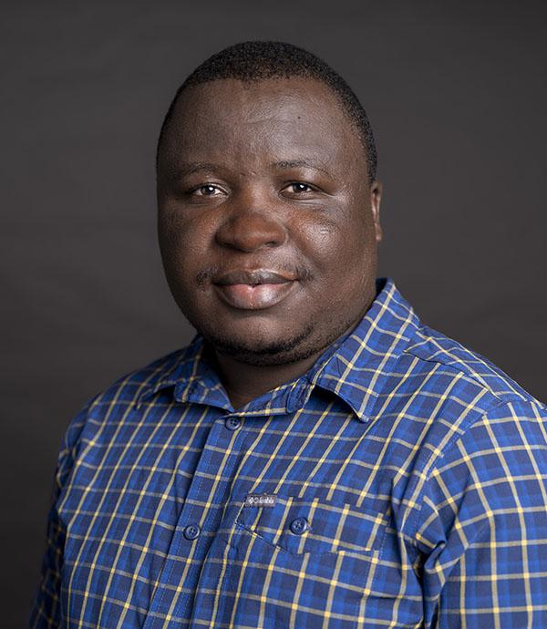 Photo of a man in a blue shirt with a white grid pattern